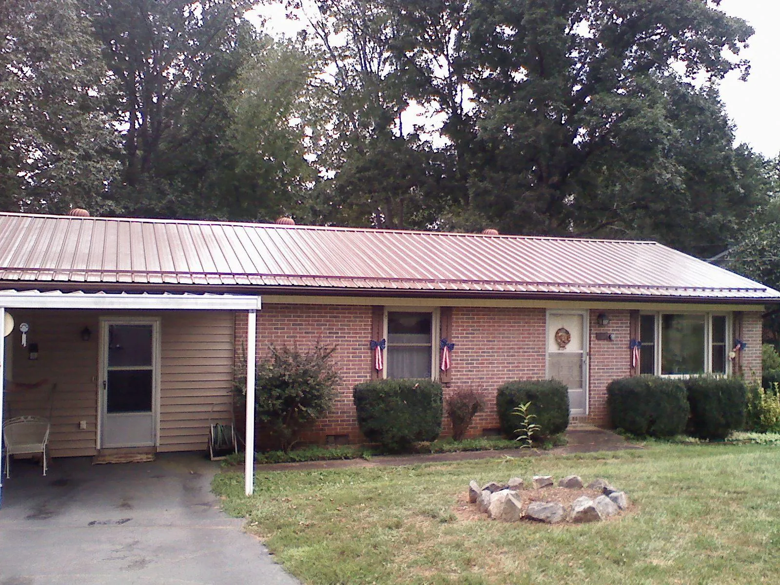 Bronze metal roof and carport on a brick ranch home — Roof Repair work by our crew in Hampton